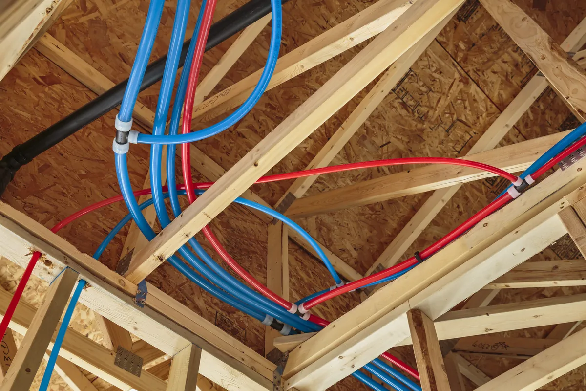 Red and blue PEX water lines run through attic trusses – Mission Viejo Homes and Rinnai Tankless Water Heater Installation for Mission Viejo, CA homes
