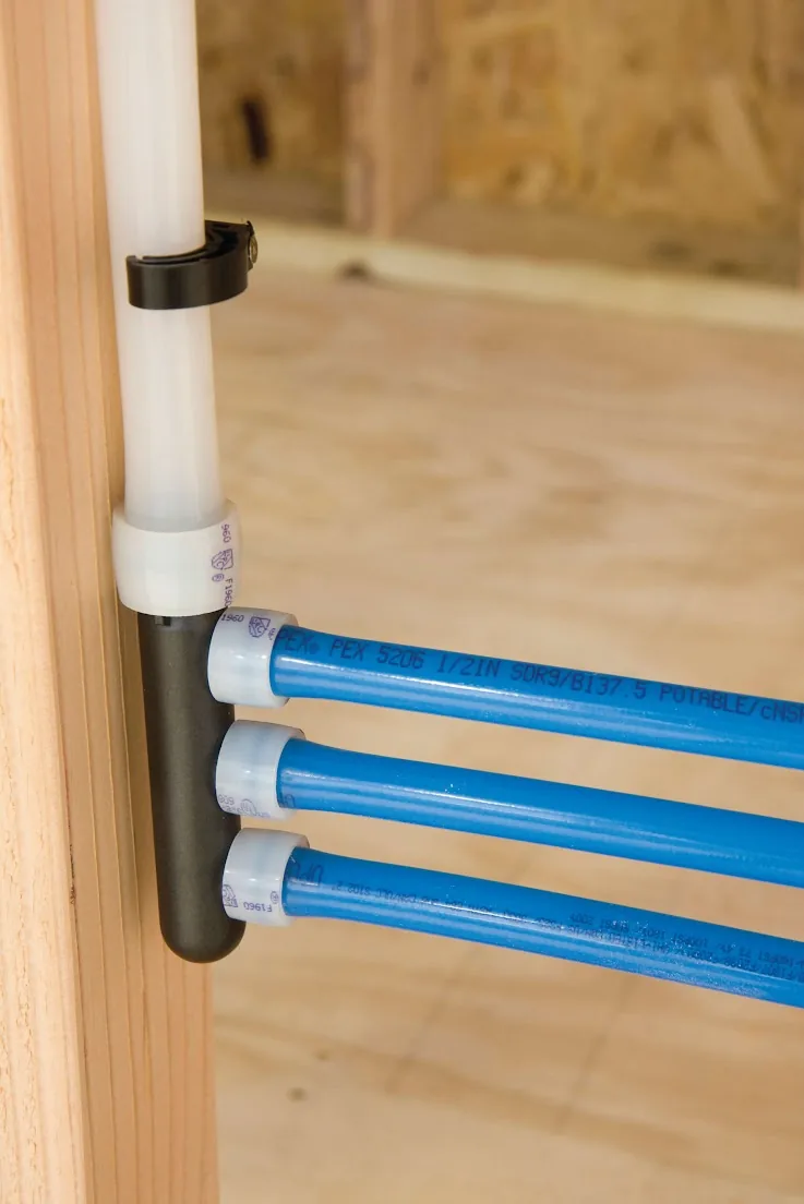 Blue PEX lines leaving a manifold fastened to a wall stud, from our Mission Viejo guide: Switching to Tankless